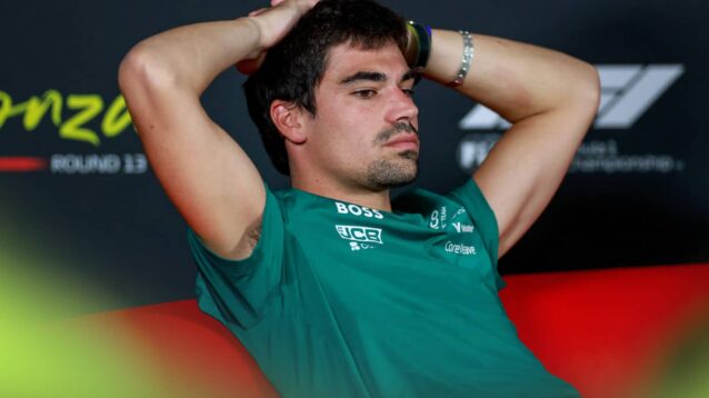 Lance Stroll holds his hands on the back of his head in a press conference
