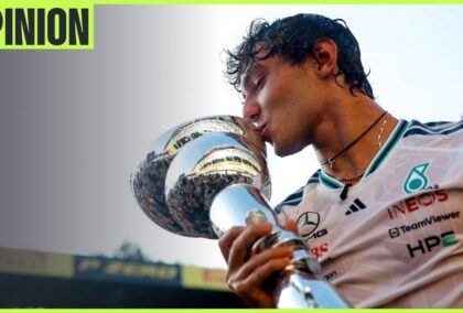 Kimi Antonelli kisses the winners' trophy at Zandvoort with the sky above him and an 'opinion' tab in the top-left corner