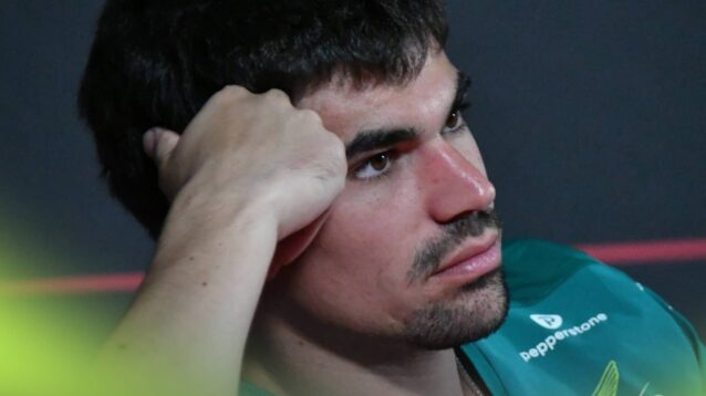 Lance Stroll rests his head on his hand in a press conference