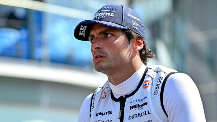 Carlos Sainz wears a cool-vest and hat in the pit lane.