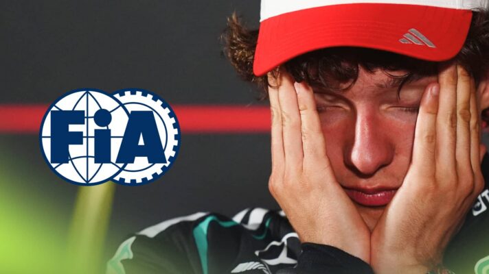 Kimi Antonelli holds his head in his hands in a press conference with a prominent FIA logo alongside him