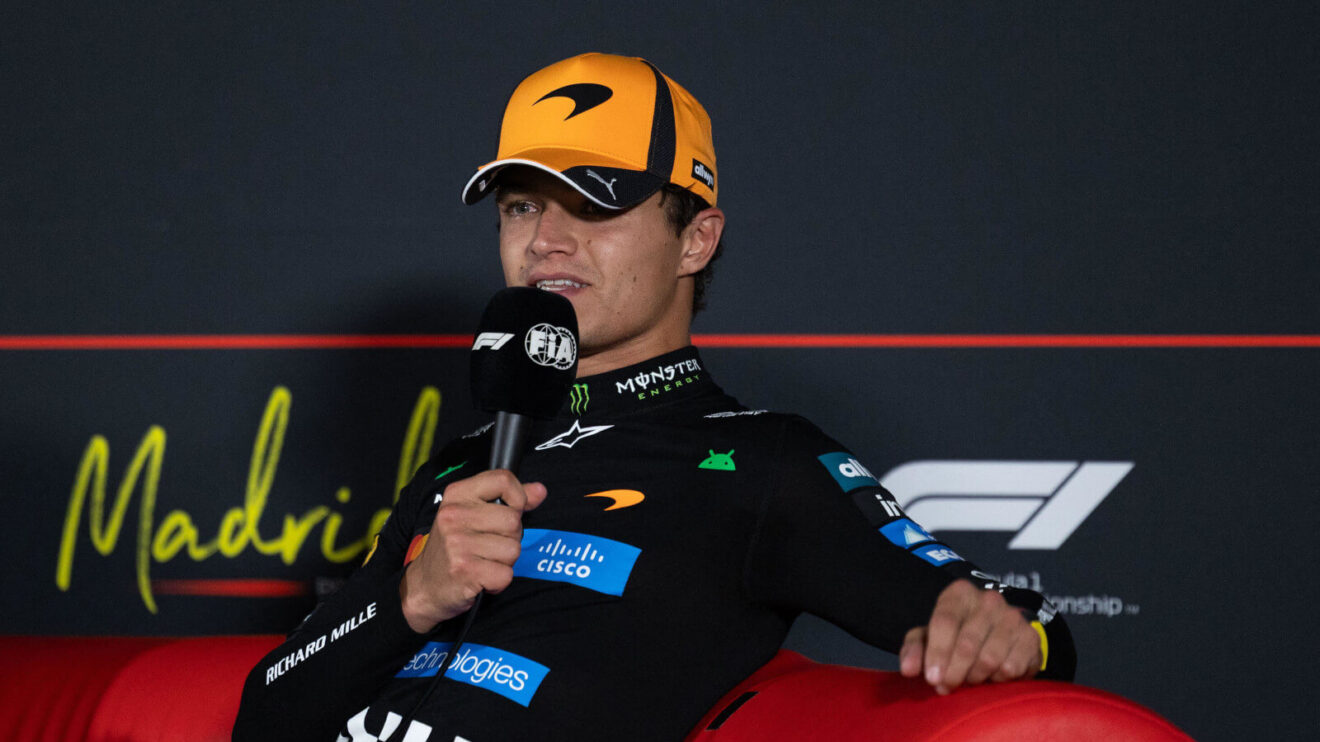 Lando Norris holding the mic to his mouth during a press conference