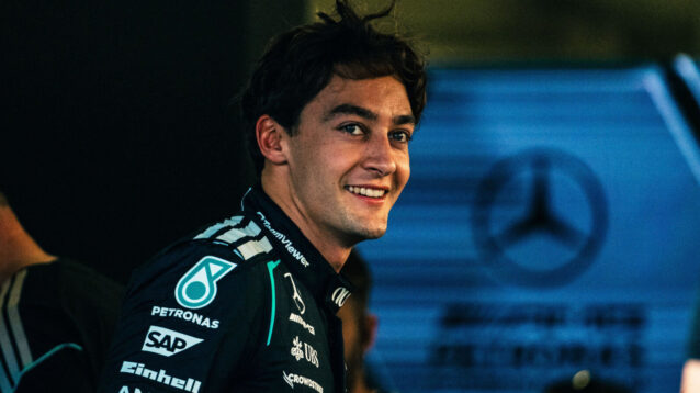 George Russell smiling in the Mercedes garage