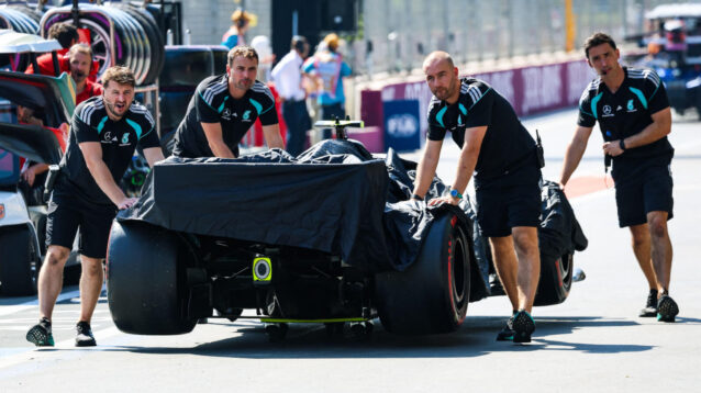 Kimi Antonelli's W17 is pushed in the pit lane by four Mercedes mechanics