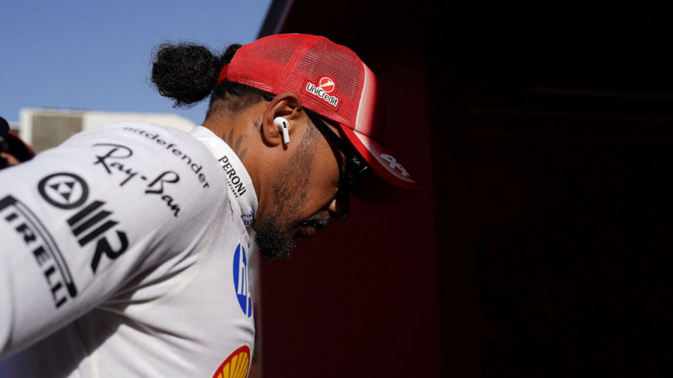 Lewis Hamilton walking, wearing his Ferrari cap