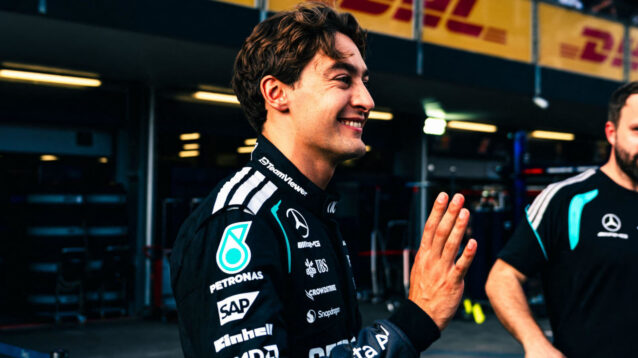 George Russell smiles and waves