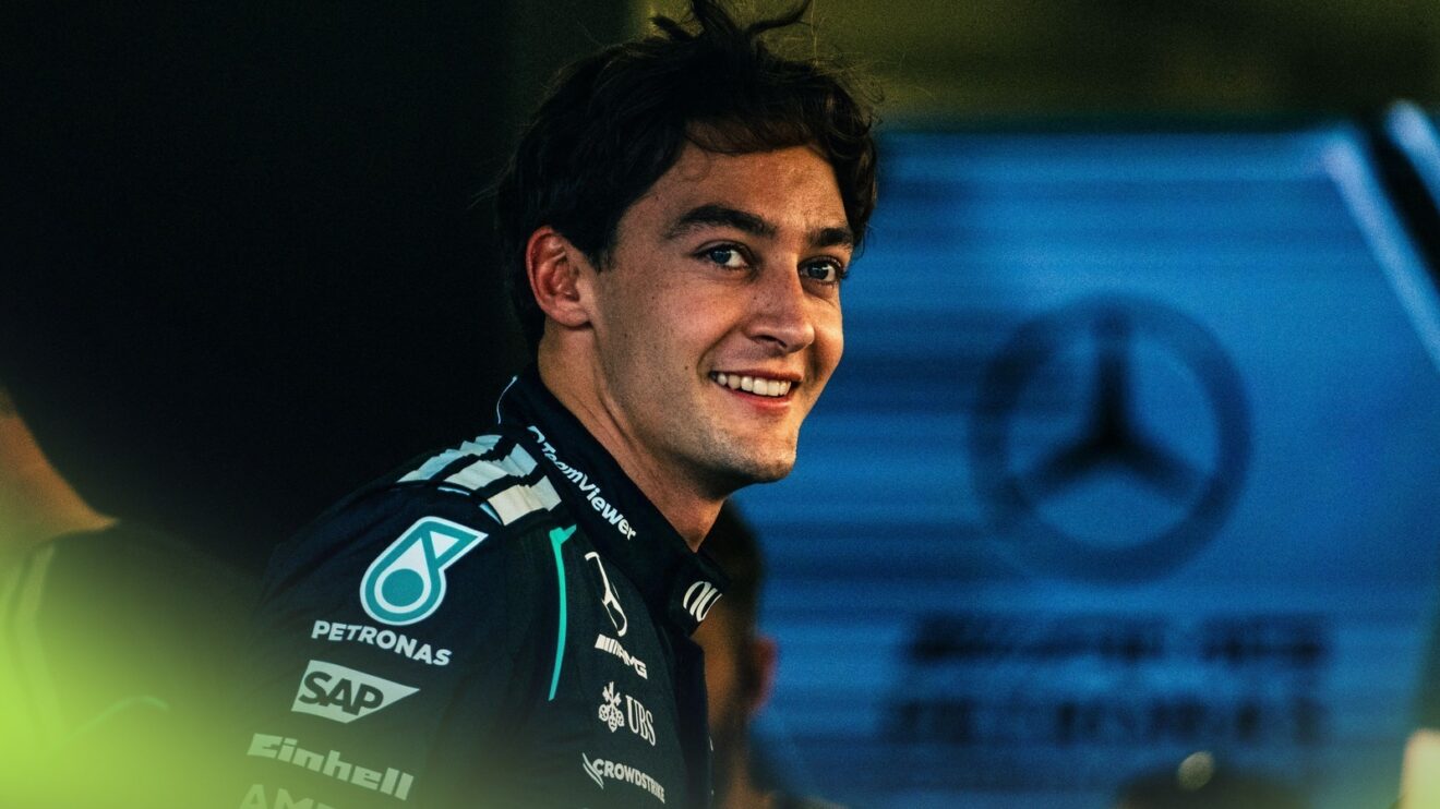A smiling George Russell in the Mercedes garage.