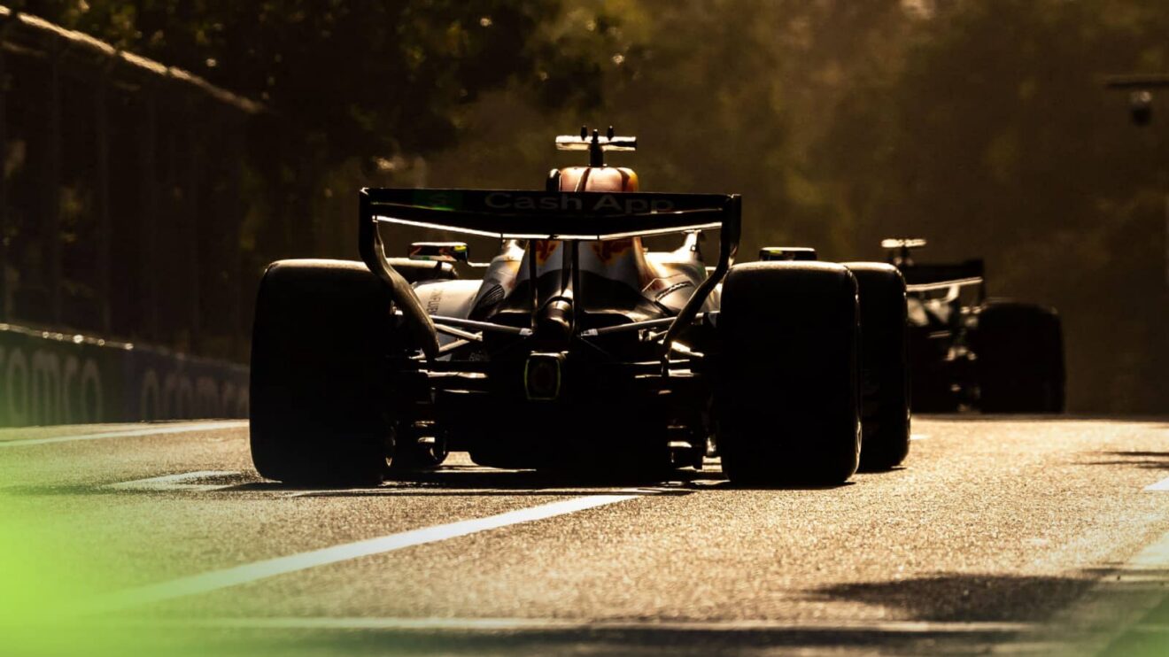 A ground-level shot of the rear of Arvid Lindblad's Racing Bulls car on track in golden light in Baku