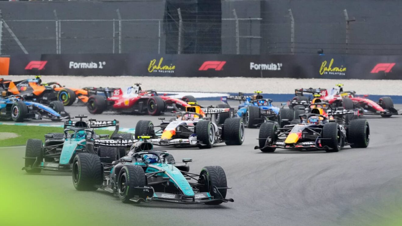 The F1 field navigates Turns 1 and 2 at the start in Sepang