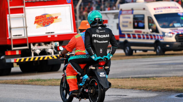 George Russell is taken back to the pit lane on a scooter