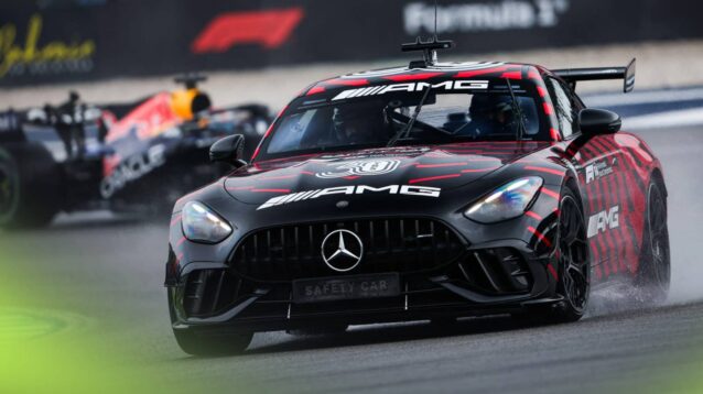 The F1 safety car on track at Sepang with Max Verstappen's Red Bull in the background