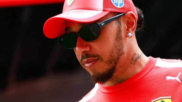 Ferrari driver Lewis Hamilton walks through the paddock.