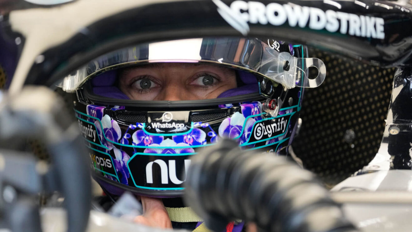 George Russell visor up sitting in his W17 in the Mercedes garage