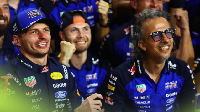 Max Verstappen and Laurent Mekies pose for Red Bull's celebrations with team members gathered in the background