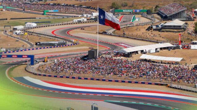 A view of the esses section at the Circuit of The Americas, with the flag of Texas above a banking of fans.