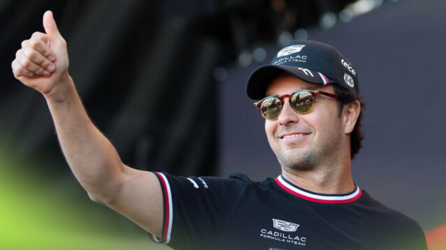 A smiling Sergio Perez waves to the crowd.